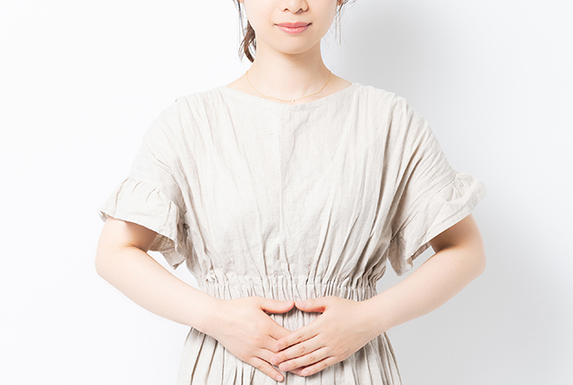 腹部を押さえている女性